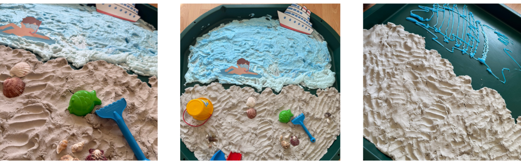 Aktivitetsbord med sandstrand, snäckor, leksaker och blått skum som föreställer hav.