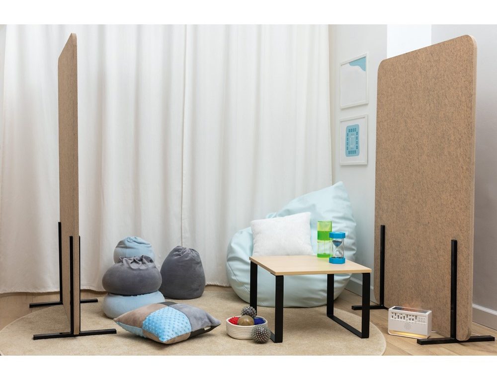 Lugn sensorisk hörna med akustiska skärmar, sittpuffar, mjuka kuddar och material för avkoppling.