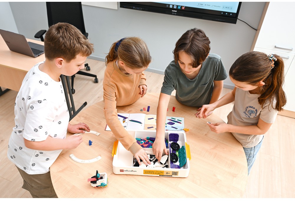 Fyra elever samarbetar med LEGO® Education och använder illustrerade bygginstruktioner för att konstruera modeller.