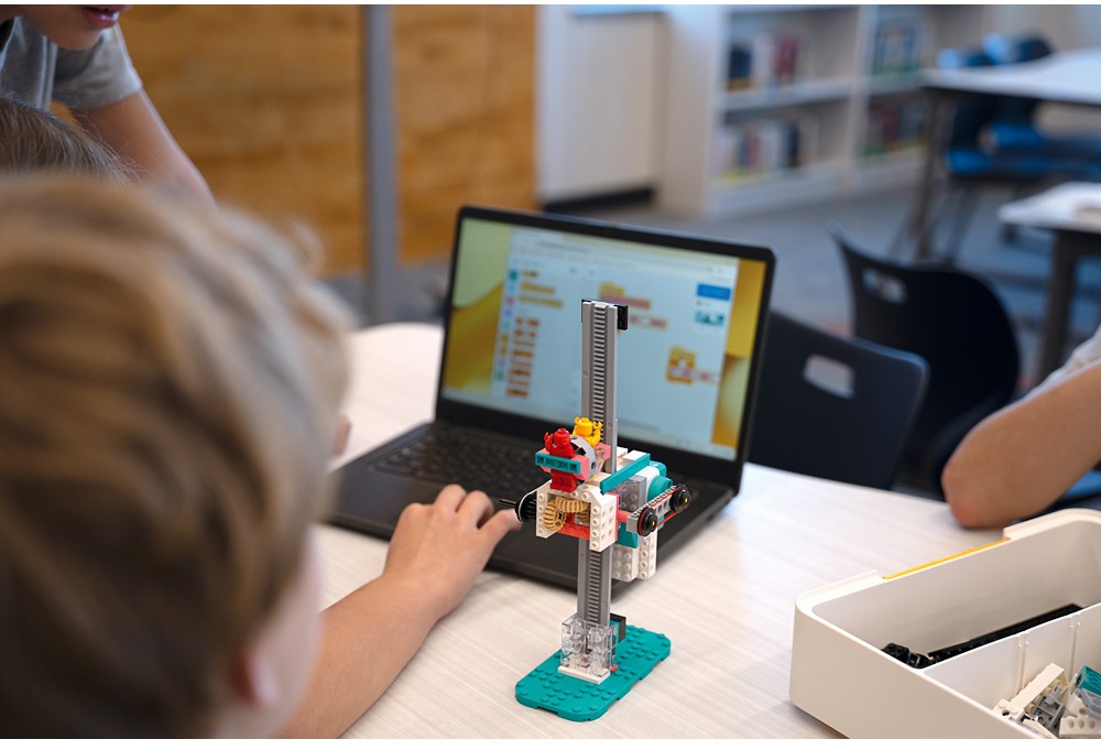 Elev programmerar en LEGO® Education-modell på en dator under undervisning i datavetenskap och AI.